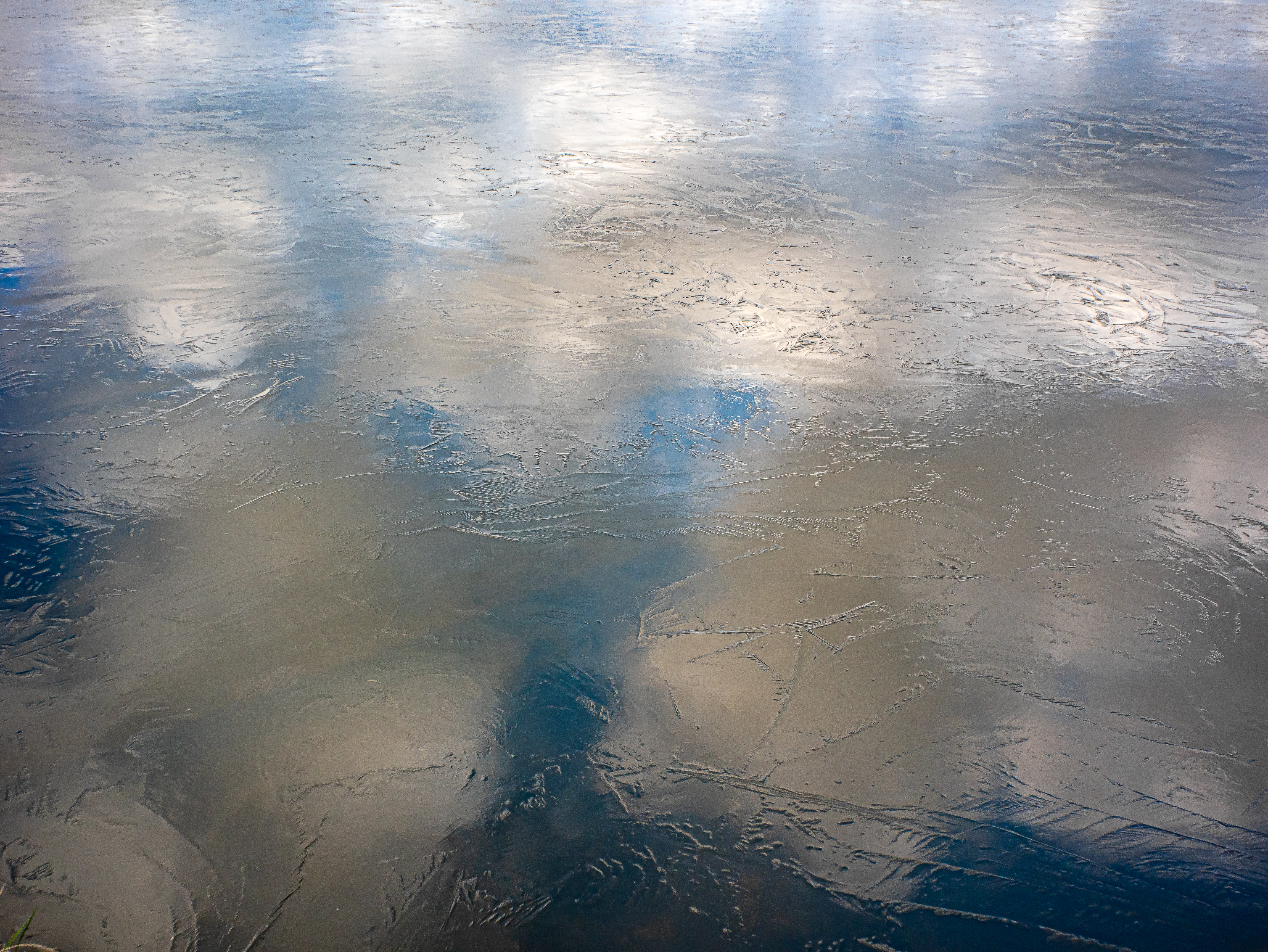 Wolken in Eisflächee gespiegelt