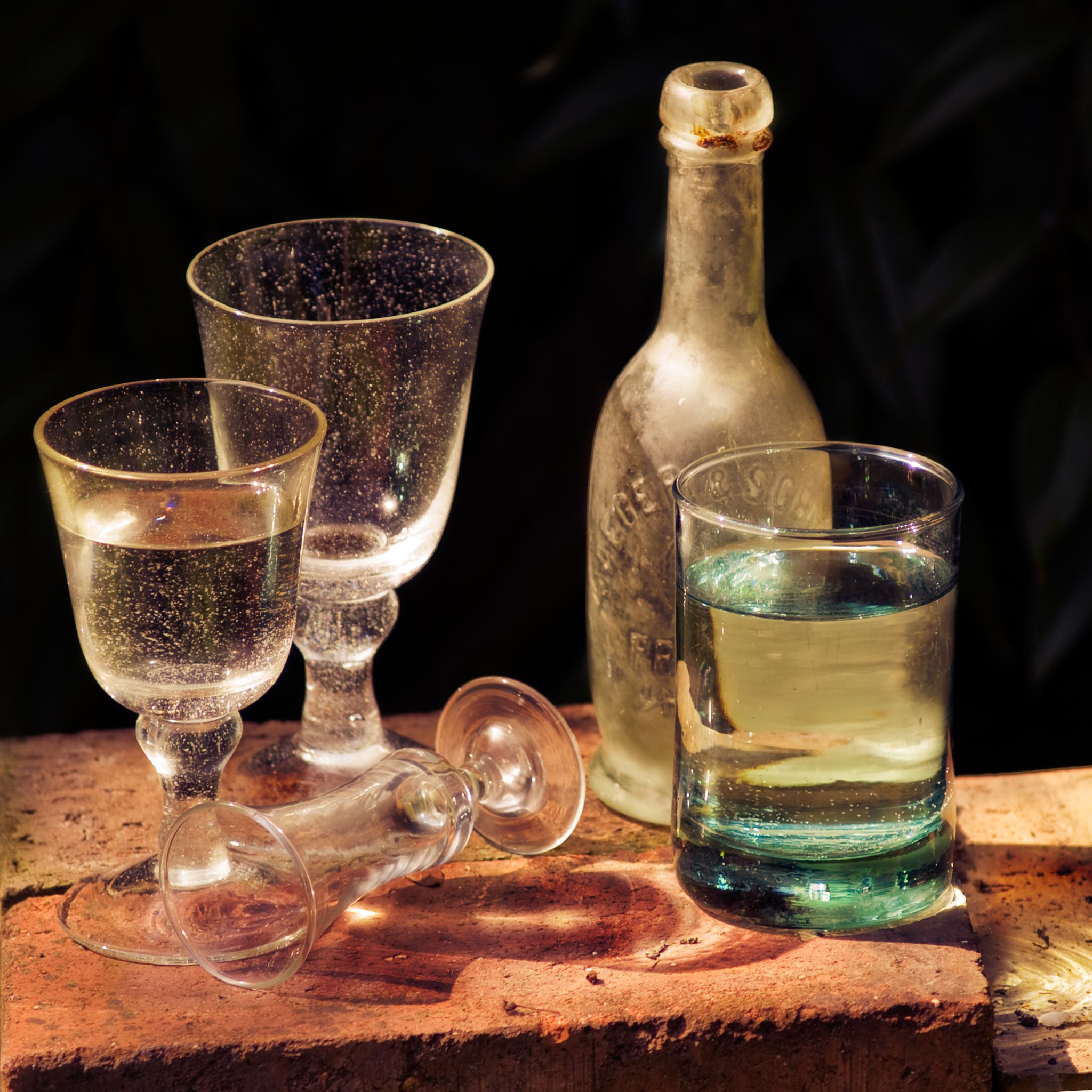 Stilleben mit Gläsern und antiker Flasche